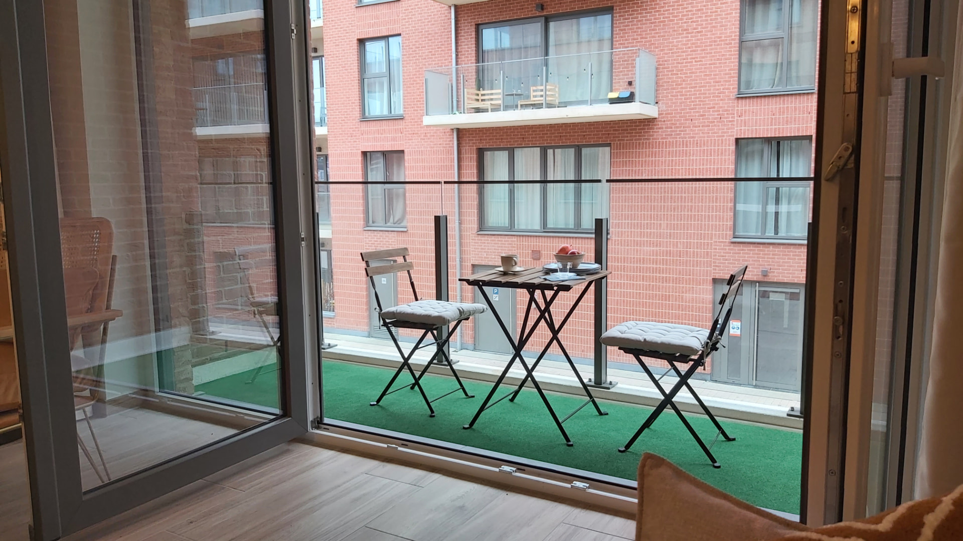 Balcon du Courbevoie lodge avec table et deux chaises en bois