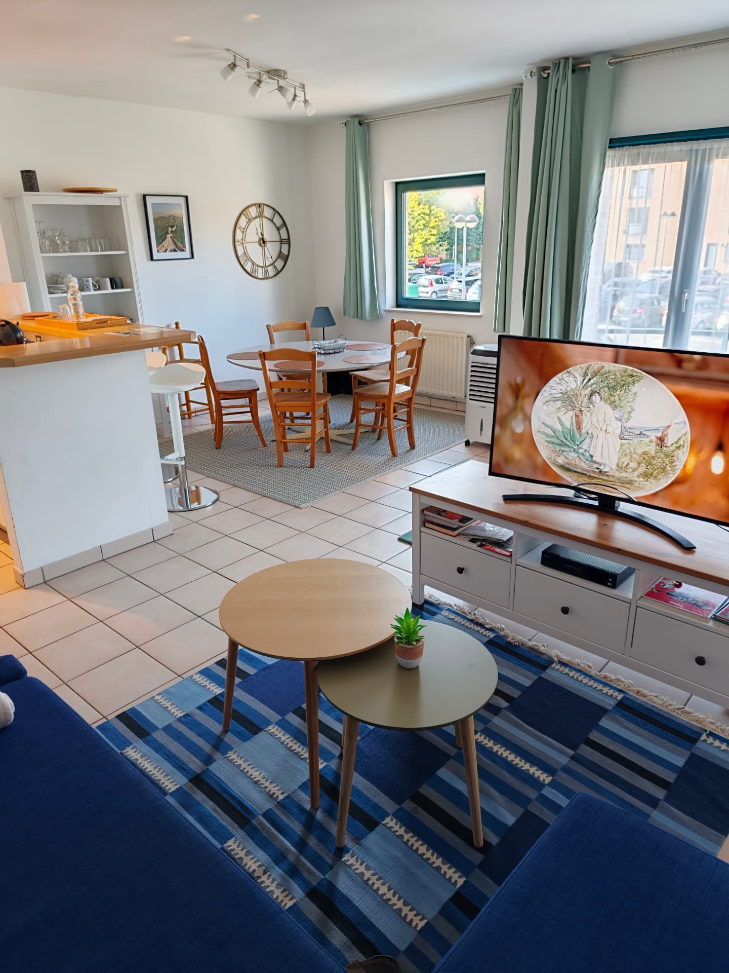 Vue d'ensemble du séjour du Bruyères lodge, du canapé bleu à la salle à manger